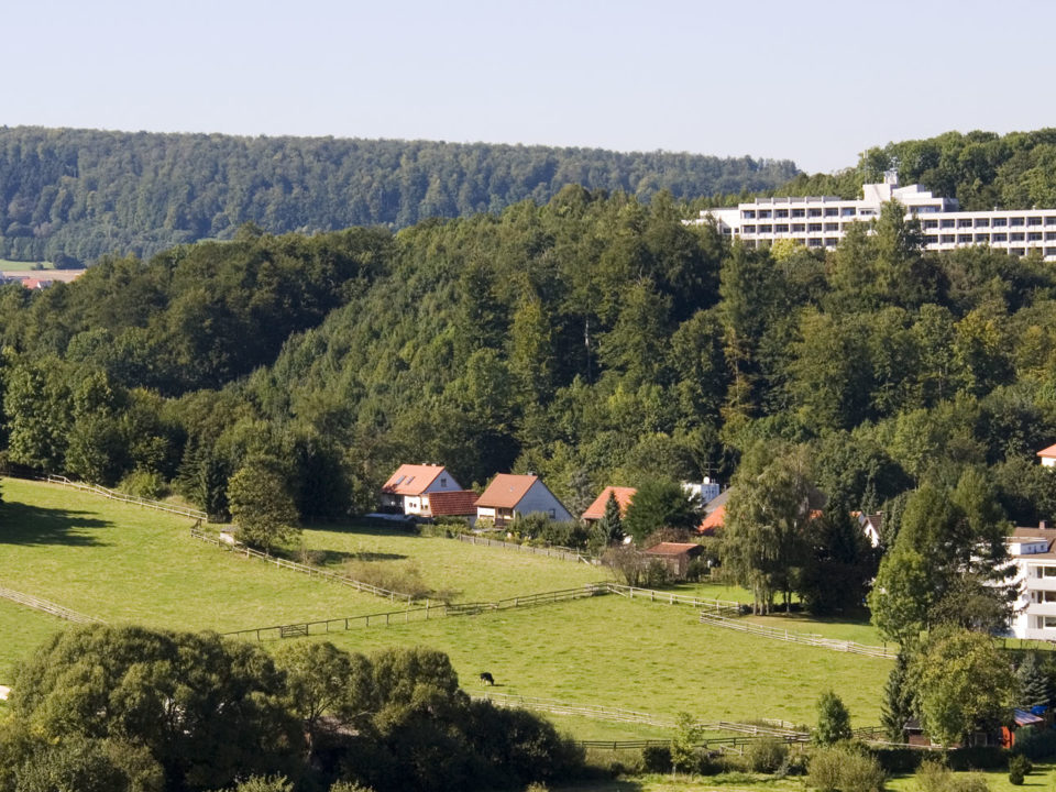 Klinikgebäude am Hang umgeben von Wald