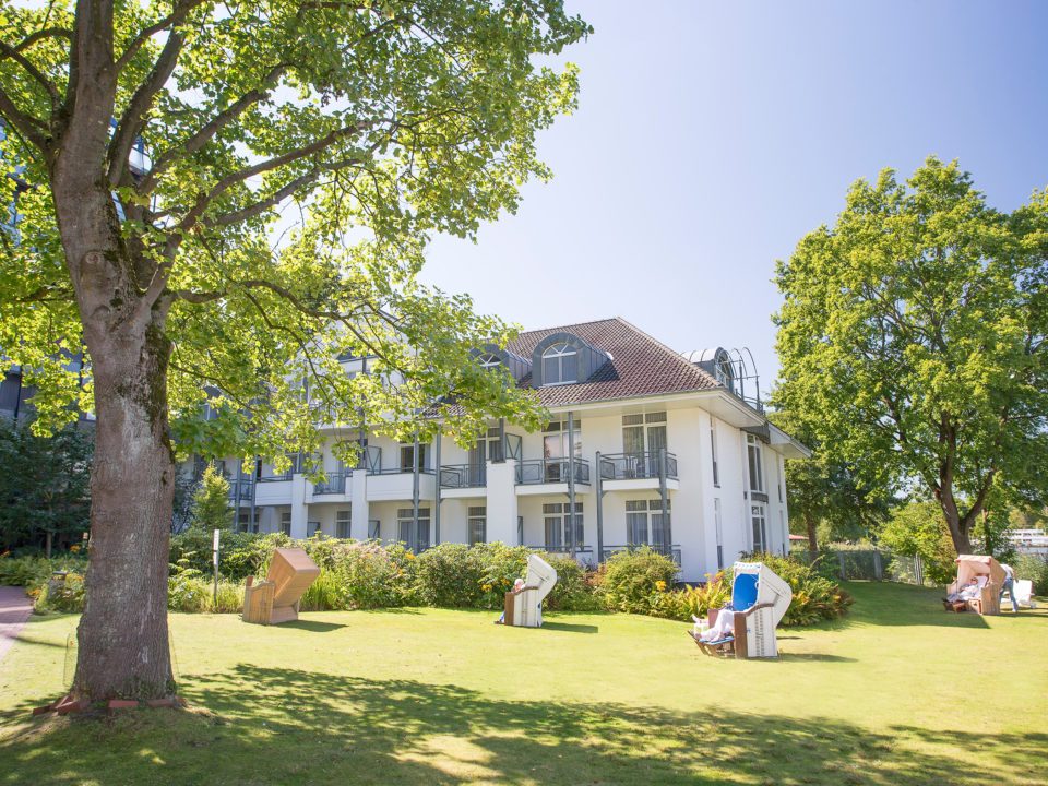 Klinikgebäude mit Strandkörben auf grüner Wiese