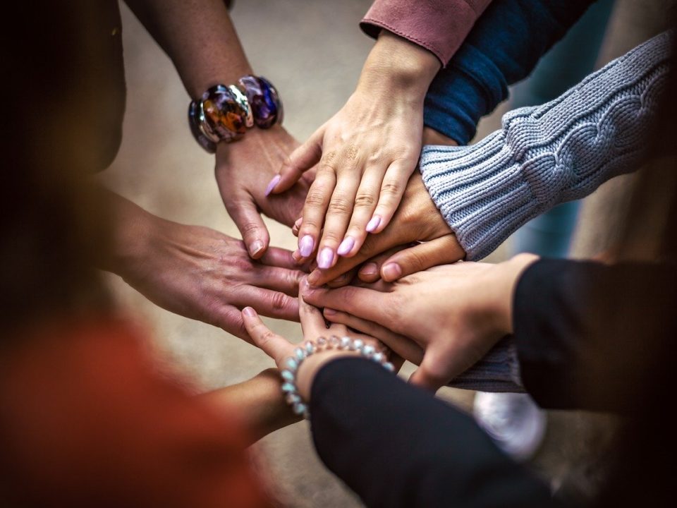 Diverse Menschen stapeln Hände zusammen