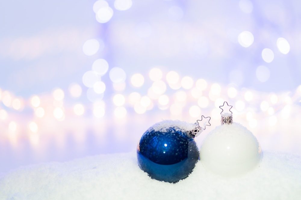 Blaue und weiße Christbaumkugel im Schnee