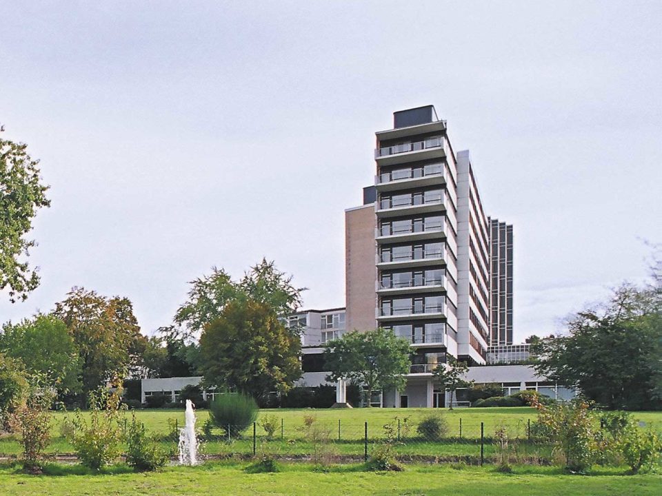 Mehrstöckiges Gebäude mit grüner Wiese